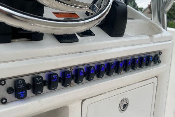 Custom Sea Hunt switch panel with blue backlit rocker switches installed below the helm