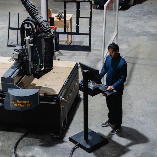 employee using cnc machine to cut tackle station parts for boat