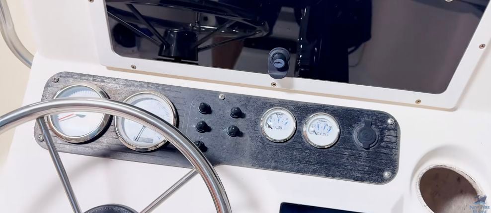 Boat switch panel before the upgrade with rubber boots around five marine toggle switches