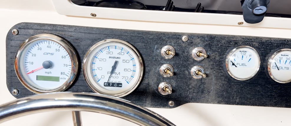 Finished boat dashboard with five marine toggle switches installed in stainless-steel beauty rings